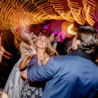 Smiling couple dancing under golden lights at Mountain Top Inn wedding reception in Vermont.