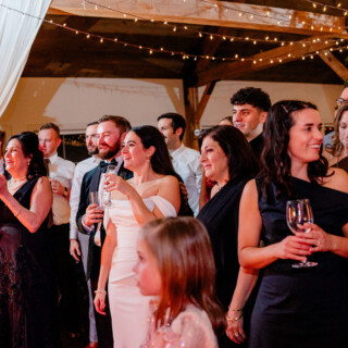 Bride and groom laughing with guests at rustic Mountain Top Inn wedding in Vermont.