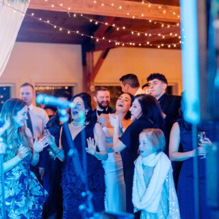 Elegant wedding reception at Mountain Top Inn Vermont with joyful guests and warm string lights.