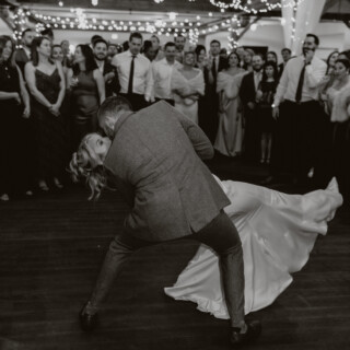 Bride and groom share a romantic black and white dance under fairy lights at Vermont wedding.