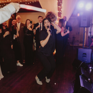 Energetic wedding dance performance under warm string lights at Mountain Top Resort in Vermont.