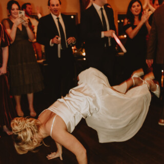 Bride performs joyful dance as wedding guests cheer at Vermont mountain resort reception.