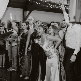 Guests celebrating joyfully at Brett and Shelby’s black-and-white wedding reception in Chittenden, Vermont.