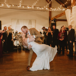Bride and groom share a romantic first dance dip at rustic Vermont wedding reception.