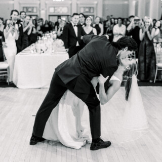 Bride and groom share a romantic dip and kiss during their elegant Omni Mount Washington wedding.
