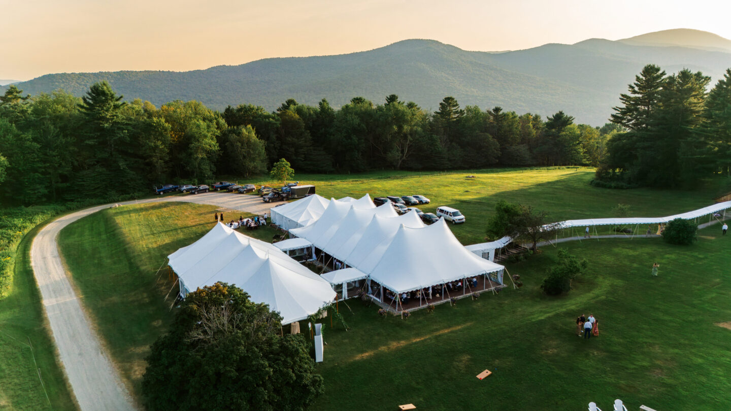 Bride and groom sharing first dance under elegant white tent at Vermont wedding celebration.